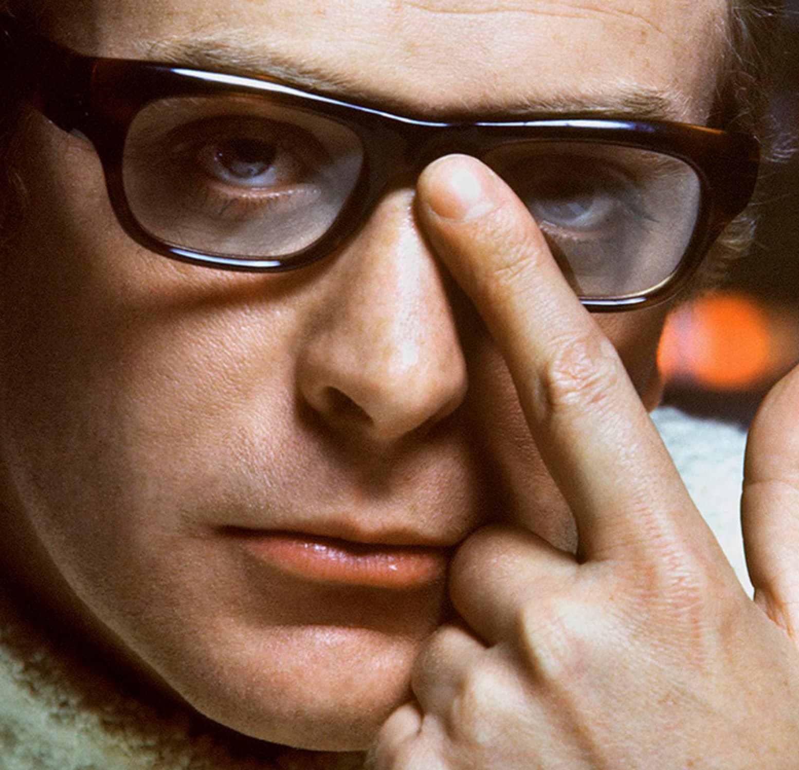 Michael Cain pushing up his glasses, 1967. 